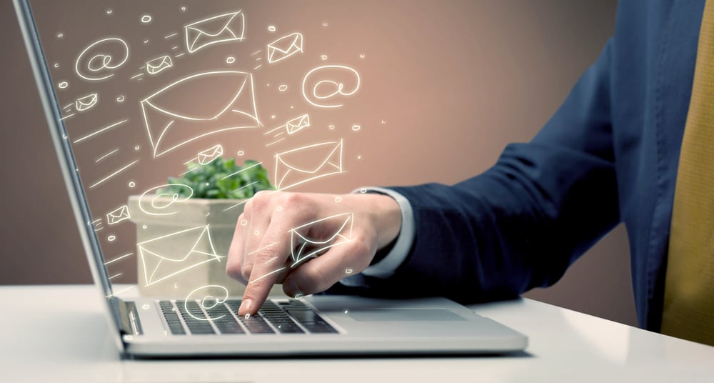 An office worker sending emails and communication with clients with the help of a portable laptop on desk concept